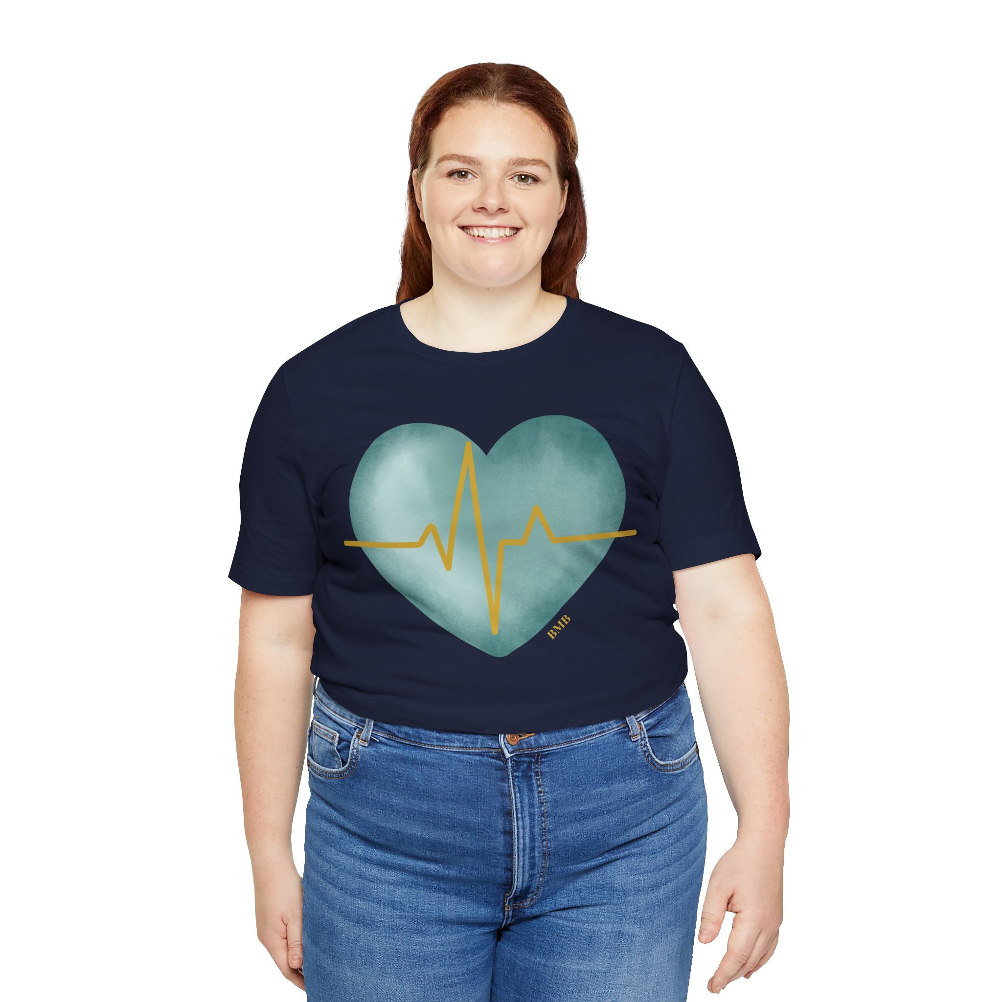 Woman wearing navy Heartbeat Heart Tee with teal watercolor heart — Nurses Week 2026 gift